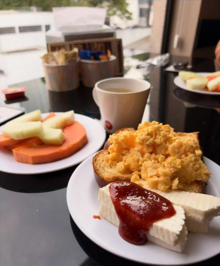 Café da manhã com ovos mexidos, queijo com goiabada e frutas