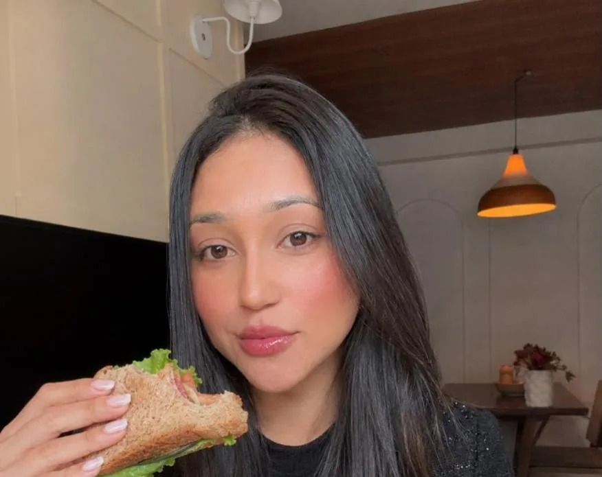 Gessica Gomes segurando um sanduíche natural